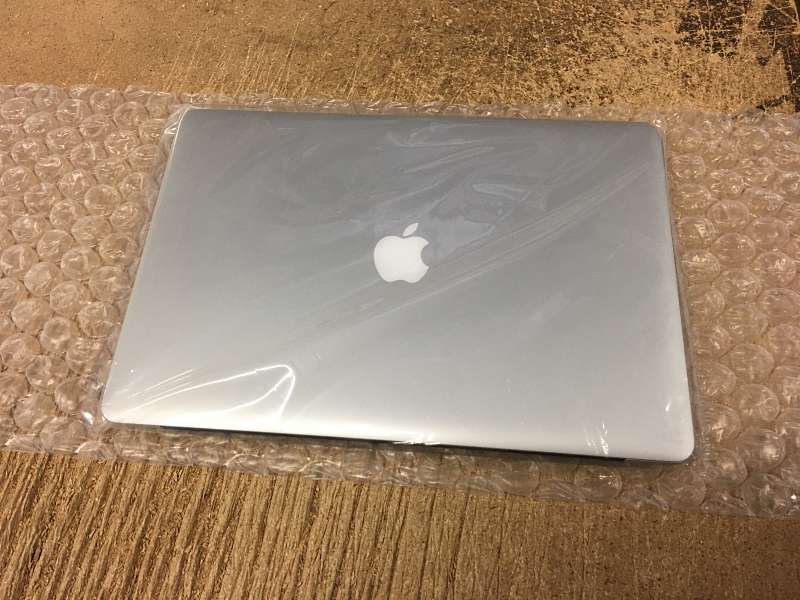 The refurbished Macbook Pro is first wrapped and sealed in a protective covering.