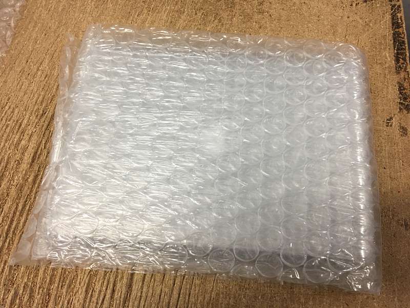 The used Macbook Pro is encased in layers of bubble wrap.